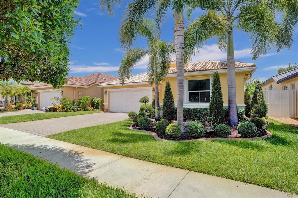 13129 Southwest 32nd Street Miramar, FL 33027 - Photo 3 of 38 a view of a house with a yard and palm trees