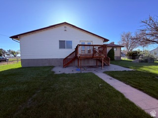 588 North 4500 West West Point, UT 84015 - Photo 54 of 61 Rear exterior featuring white horizontal siding, a gabled roofline, and a raised wood-finish deck with railings and stairs