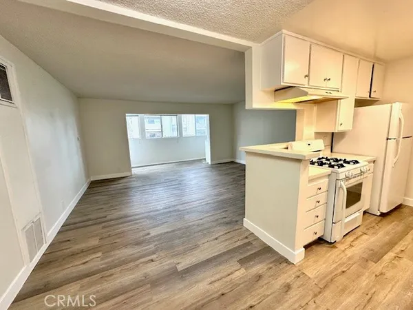 a kitchen with stainless steel appliances a white stove top oven and white cabinets
