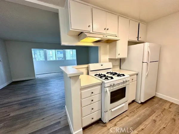 a kitchen with stainless steel appliances a stove a refrigerator and a hard wood floor