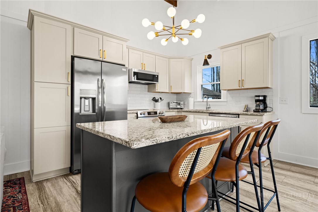 811 Pine Ridge Road Beech Mountain, NC 28604 - Photo 8 of 26 a kitchen with stainless steel appliances granite countertop a sink a stove a refrigerator with a dining table and chairs