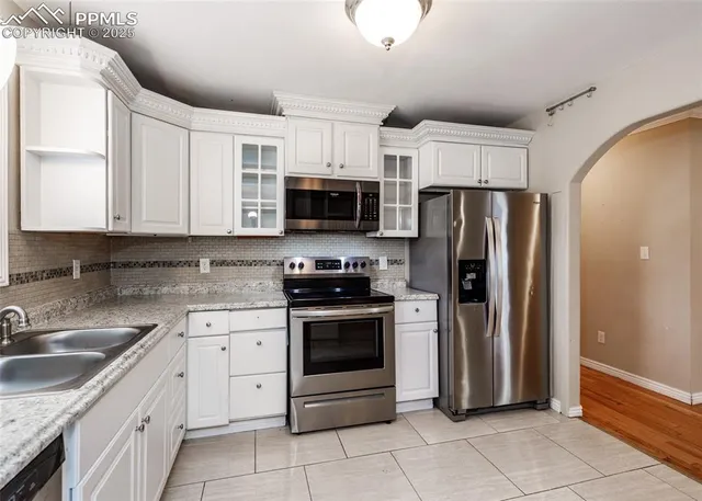 a kitchen with stainless steel appliances granite countertop a refrigerator stove and sink