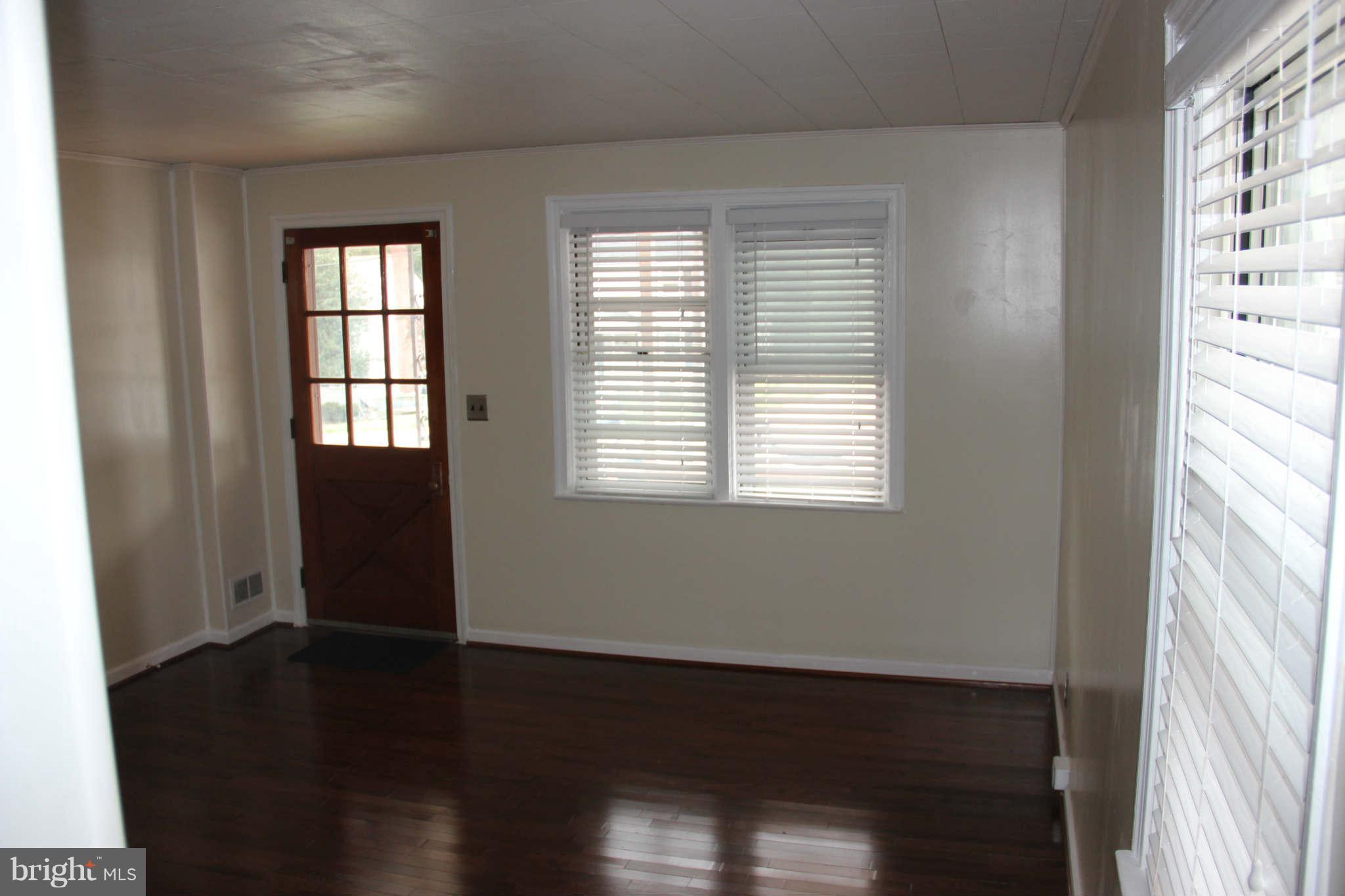 8424 Oakleigh Road Baltimore, MD 21234 - Photo 3 of 11 a view of an empty room with wooden floor and a window