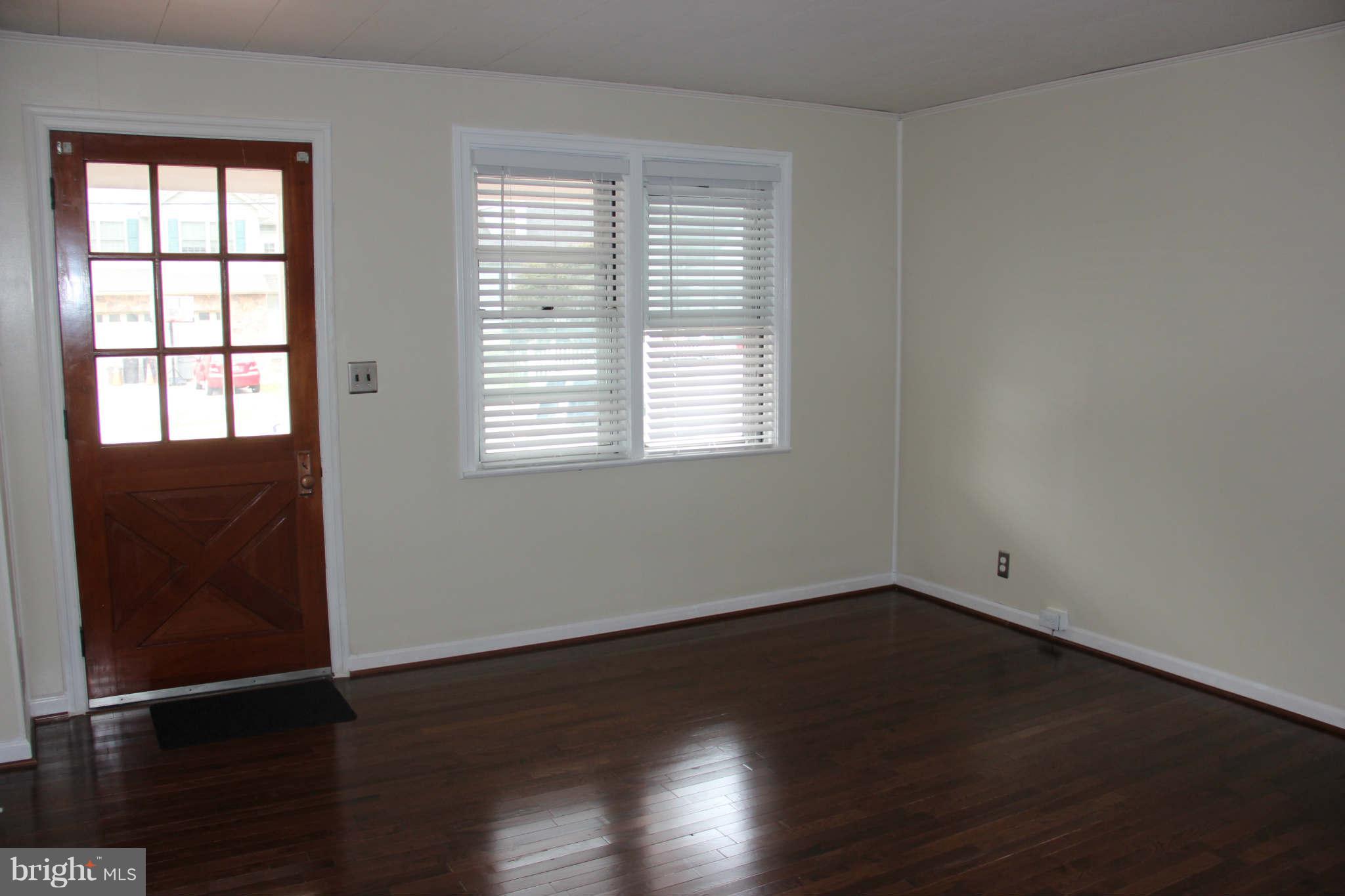 8424 Oakleigh Road Baltimore, MD 21234 - Photo 5 of 11 an empty room with wooden floor and windows