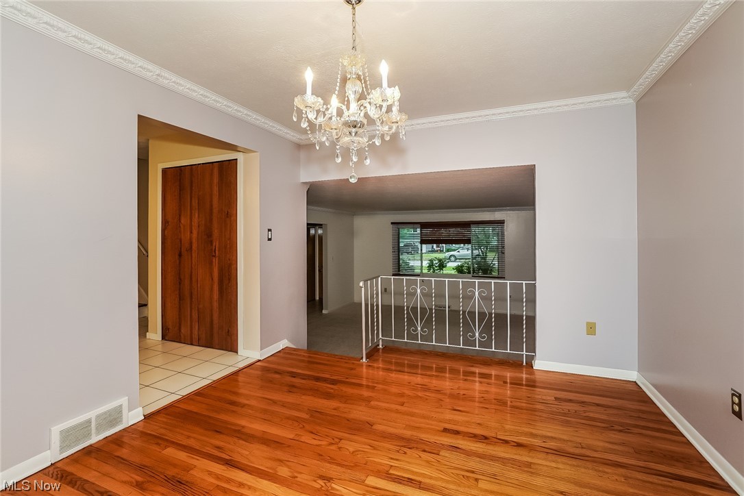 1345 Ford Road Lyndhurst, OH 44124 - Photo 5 of 20 Unfurnished room featuring an inviting chandelier, ornamental molding, and light hardwood / wood-style flooring