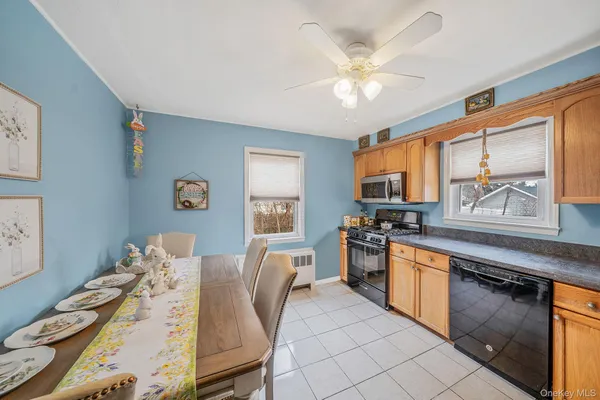 a kitchen with stainless steel appliances granite countertop a stove top oven a sink a dining table and chairs with wooden floor