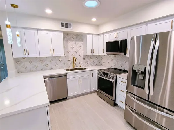 a kitchen with stainless steel appliances a refrigerator sink and microwave