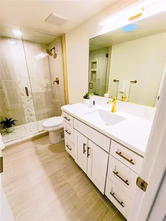a bathroom with a sink a toilet and shower