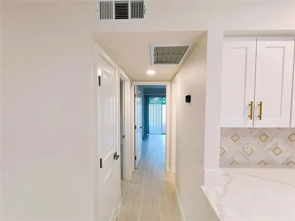 a view of a livingroom with wooden floor and a bathroom space