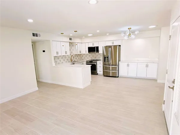 a view of kitchen with refrigerator cabinets and microwave