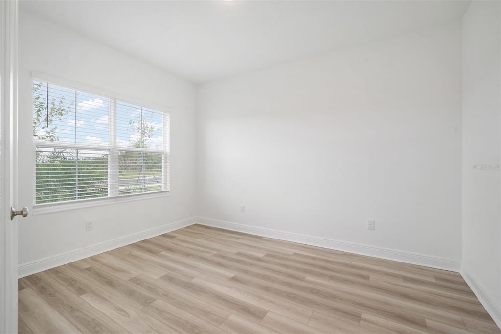10705 Wading River Avenue Parrish, FL 34219 - Photo 11 of 28 a view of an empty room with wooden floor and a window