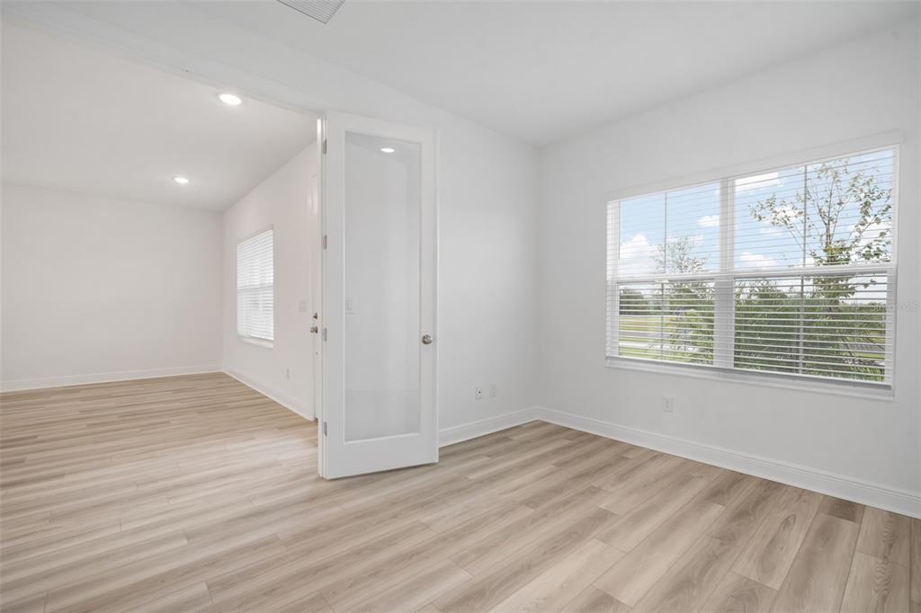 10705 Wading River Avenue Parrish, FL 34219 - Photo 12 of 28 a view of an empty room with wooden floor and a window