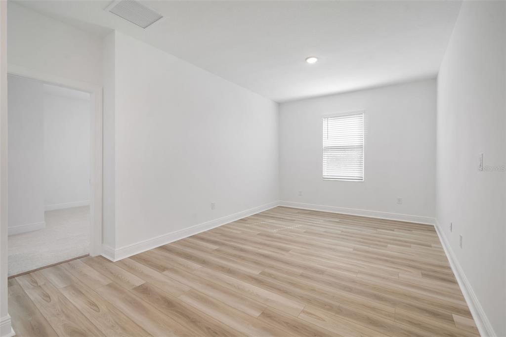 10705 Wading River Avenue Parrish, FL 34219 - Photo 14 of 28 an empty room with wooden floor and windows