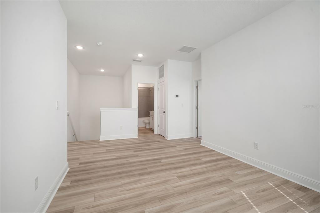 10705 Wading River Avenue Parrish, FL 34219 - Photo 17 of 28 a view of an empty room with wooden floor and a window