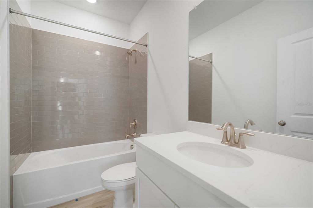 10705 Wading River Avenue Parrish, FL 34219 - Photo 25 of 28 a bathroom with a sink a toilet and a large mirror