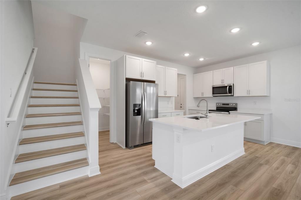 10705 Wading River Avenue Parrish, FL 34219 - Photo 9 of 28 a view of kitchen with stainless steel appliances granite countertop a refrigerator oven a sink and dishwasher with wooden floor