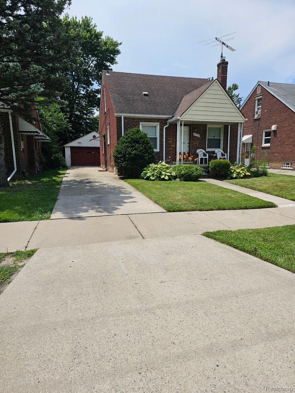 21970 Moross Road Grosse Pointe, MI 48236 - Photo 1 of 21 Brick residence featuring a covered front porch, gabled roofline, and established landscaping