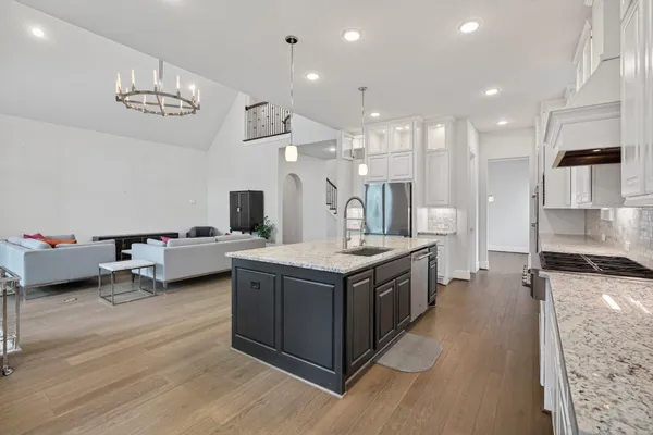 a view of an empty room with wooden floor and a ceiling fan