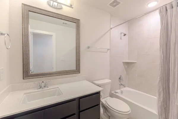 a bathroom with a granite countertop sink and a toilet