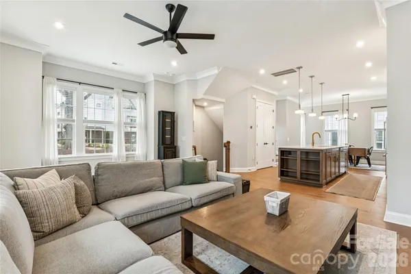 a living room with furniture and a view of kitchen