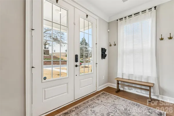 a view of a hallway with wooden floor and entryway