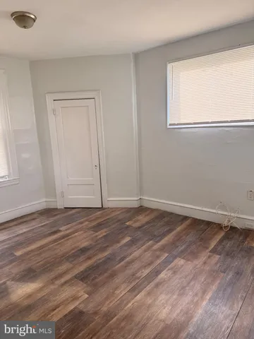 a view of a livingroom with wooden floor and window