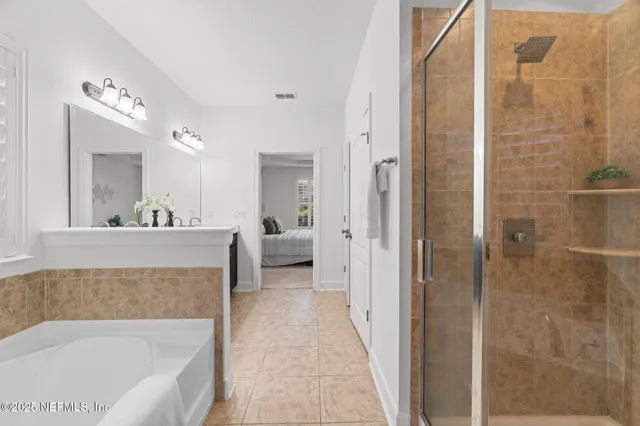 a en suite bathroom with a tub shower and a sink