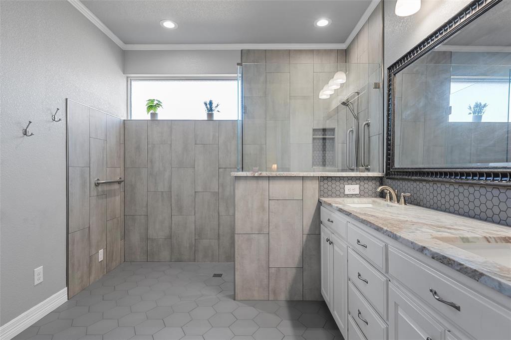 1420 Hoosier Park Robinson, TX 76706 - Photo 15 of 40 Primary Bathroom featuring crown molding, a custom walk-in tiled shower, double vanity, light tile patterned floors