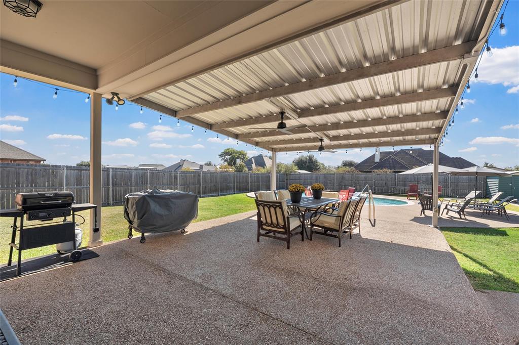 1420 Hoosier Park Robinson, TX 76706 - Photo 28 of 40 Privacy Fenced backyard featuring an extended covered patio, outdoor dining space, and ceiling fans