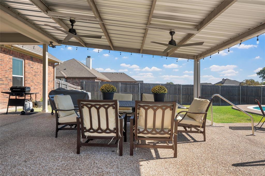1420 Hoosier Park Robinson, TX 76706 - Photo 29 of 40 Privacy fenced backyard featuring ceiling fans, outdoor dining area, and an extended patio area