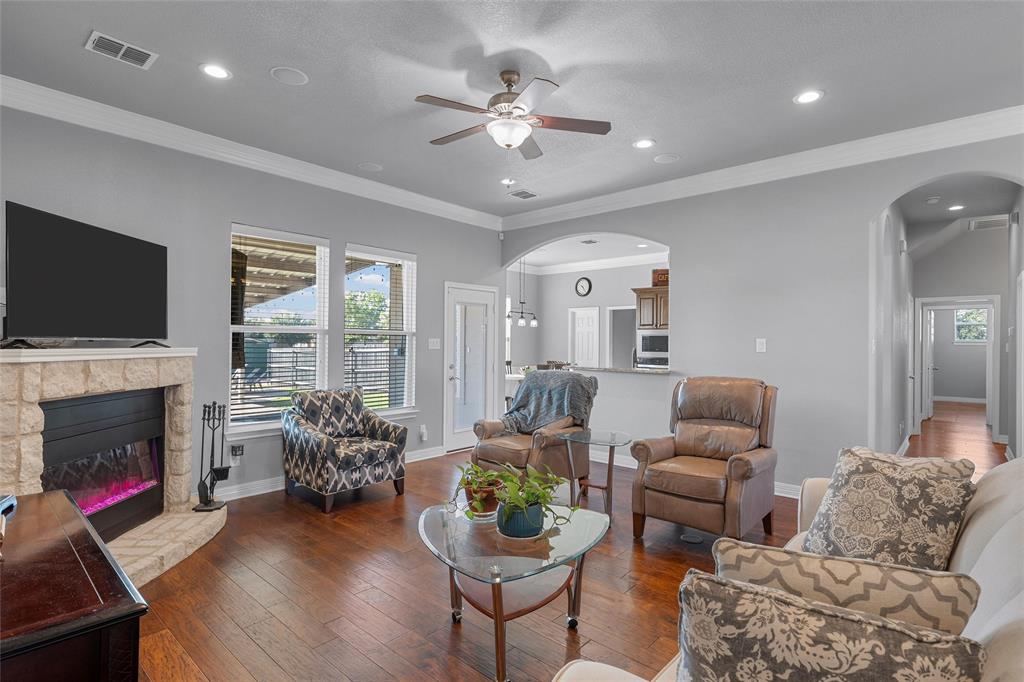 1420 Hoosier Park Robinson, TX 76706 - Photo 4 of 40 Living area featuring hardwood flooring, plenty of natural light, crown molding, a fireplace, and arched walkways