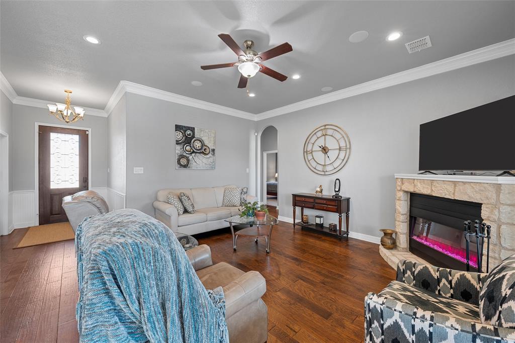 1420 Hoosier Park Robinson, TX 76706 - Photo 5 of 40 hardwood flooring, crown molding, a fireplace, arched walkways, and a ceiling fan