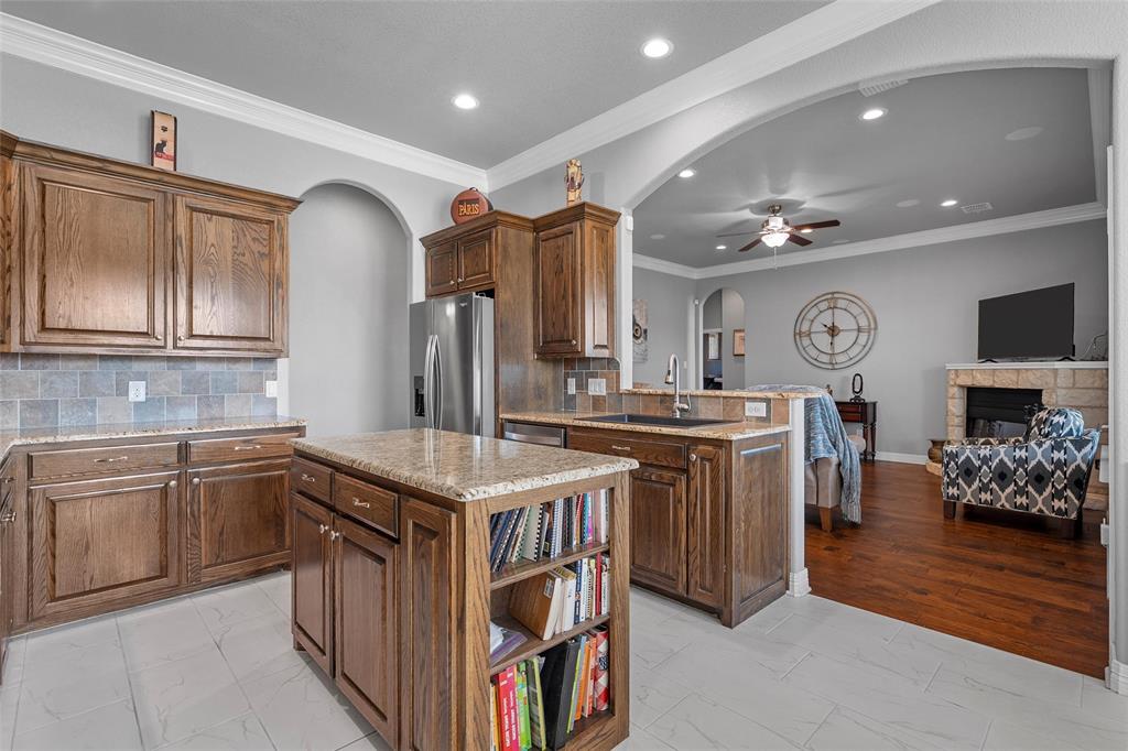 1420 Hoosier Park Robinson, TX 76706 - Photo 10 of 40 Kitchen featuring ornamental molding, backsplash, granite countertops, center island, open to living area