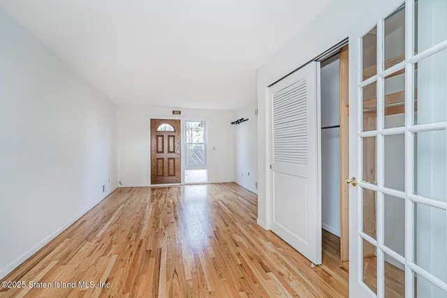 a view of empty room with wooden floor