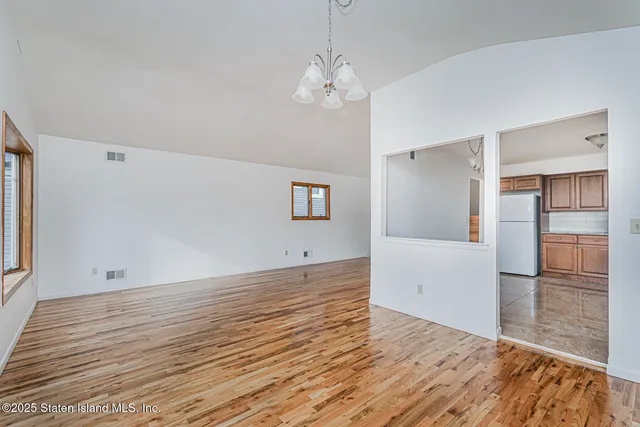 a view of a room with wooden floor and a ceiling fan