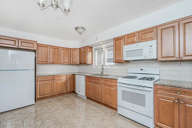 a kitchen with stainless steel appliances granite countertop a refrigerator sink stove microwave and cabinets