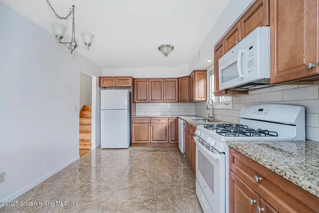 a kitchen with stainless steel appliances granite countertop a stove a refrigerator and a sink