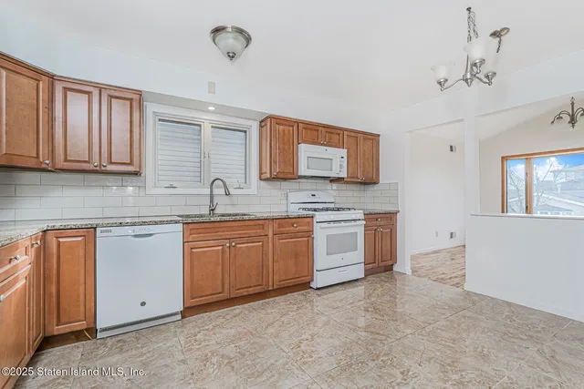 a kitchen with granite countertop a sink stainless steel appliances and cabinets