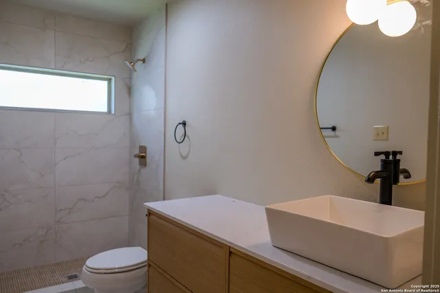 a bathroom with a sink a toilet and shower