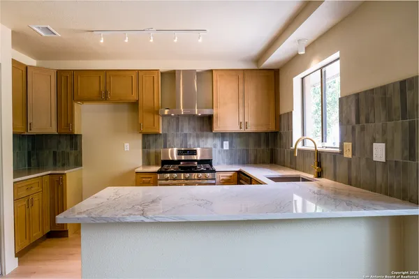 a kitchen with a sink a stove and a cabinets