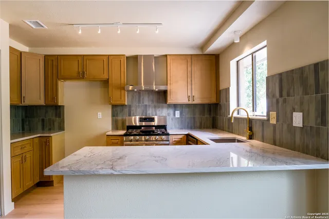 a kitchen with a sink a stove and a cabinets