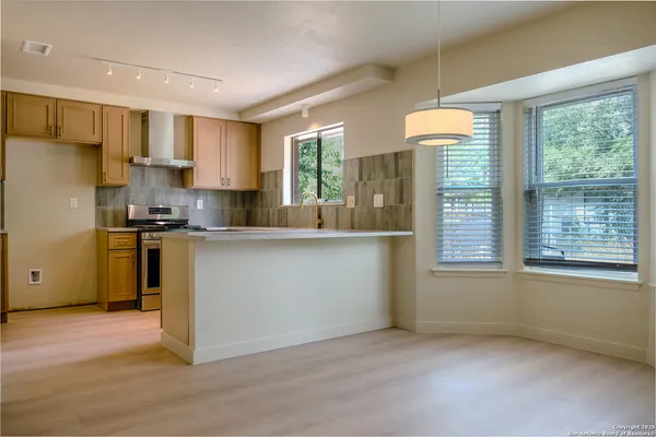 a kitchen with kitchen island a counter top space a sink stainless steel appliances and cabinets