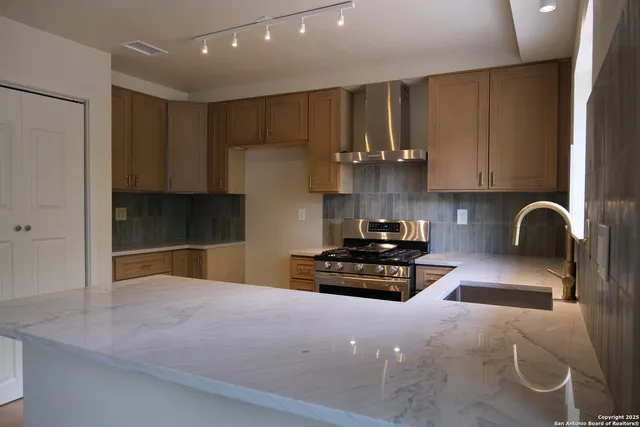 a kitchen with granite countertop a stove a sink and a granite counter tops