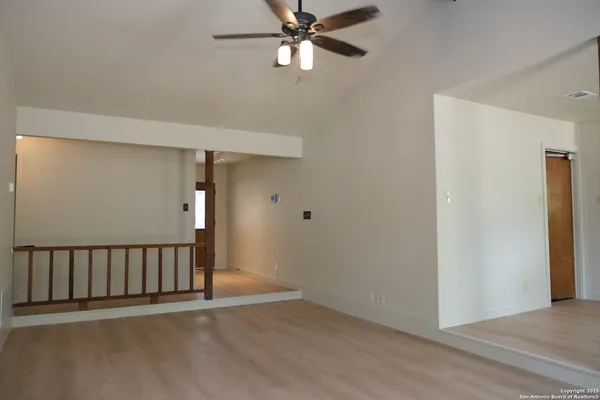 a view of a hallway with a chandelier fan