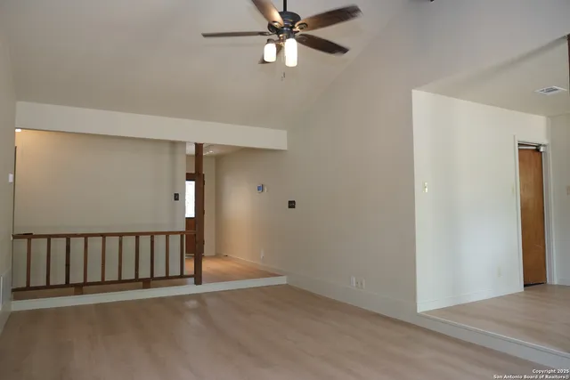 a view of a hallway with a chandelier fan