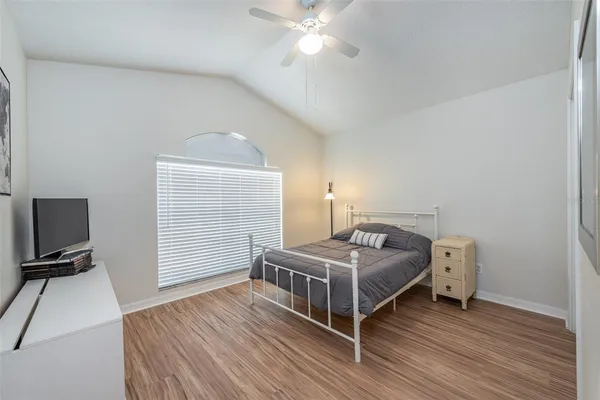 a bedroom with a bed and a flat tv screen on the dresser