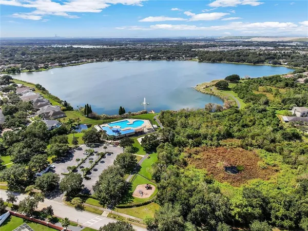 an aerial view of a house with swimming pool and outdoor seating