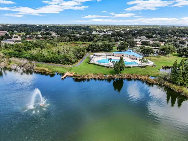 an aerial view of a house with garden space and a lake view