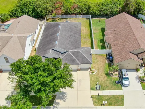 an aerial view of residential houses with outdoor space and parking