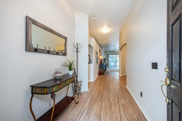a view of a hallway with wooden floor and stairs